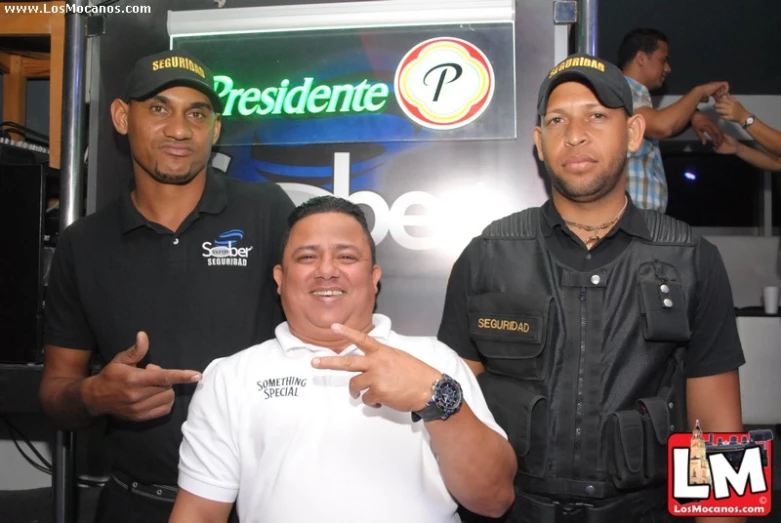 a man standing next to a smiling cop and another uniformed policeman