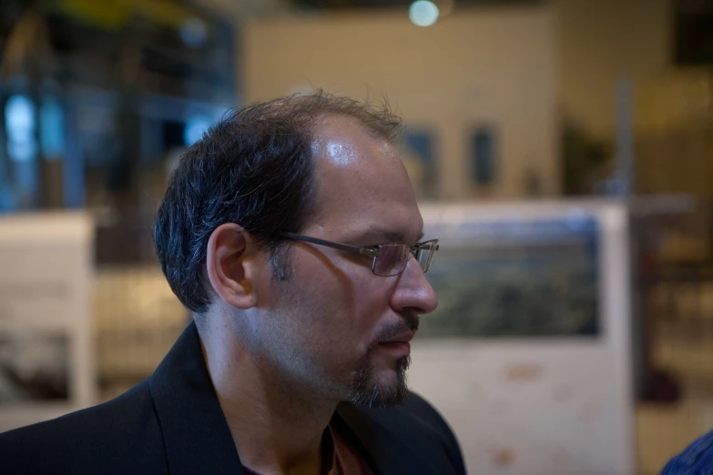 a close up of a man with glasses and a suit