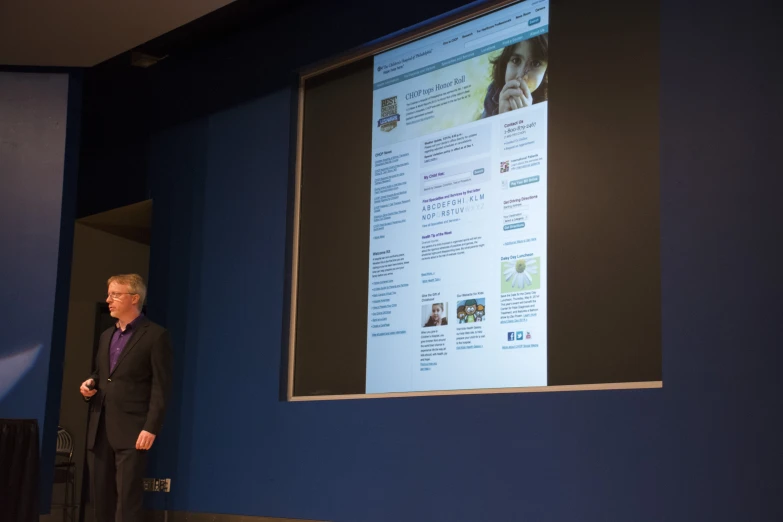 a man standing in front of a projection screen