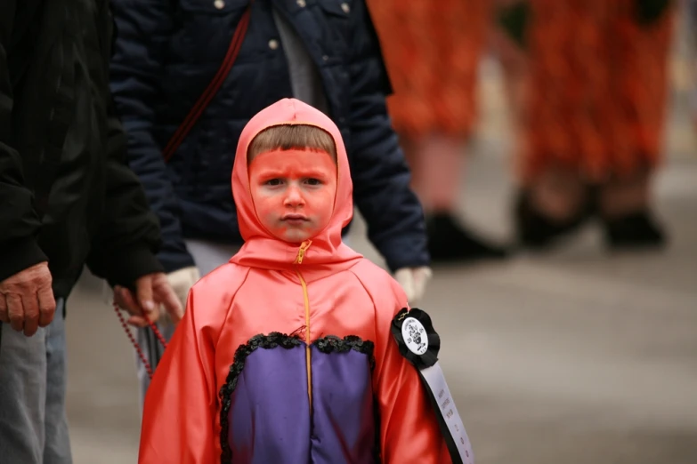 little  in bright and bright orange costume on a city street