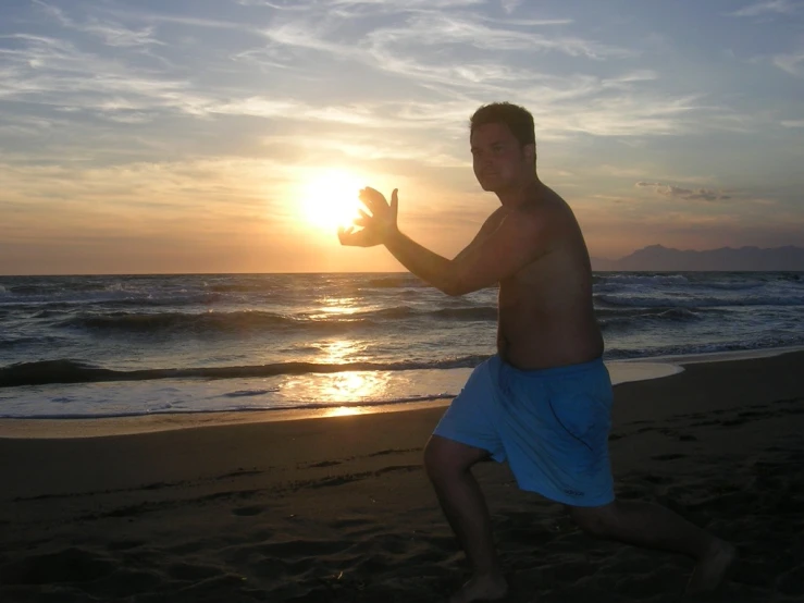 a man running on the beach with the sun in the background