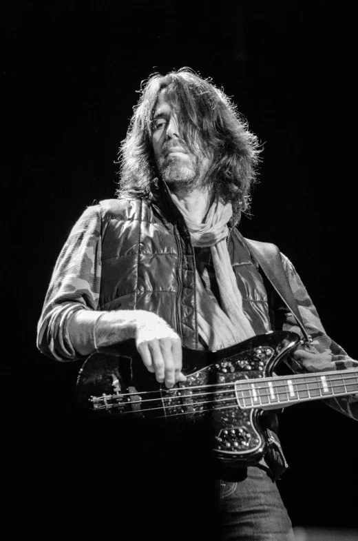 a man playing guitar with dark background