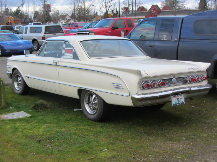 an antique car in the midst of a gathering of cars