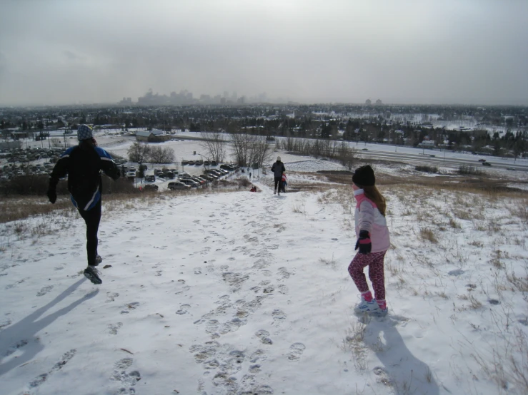 three people walking on a snow covered field