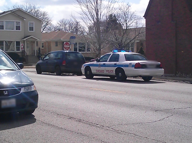 a police car is parked in the street in front of houses