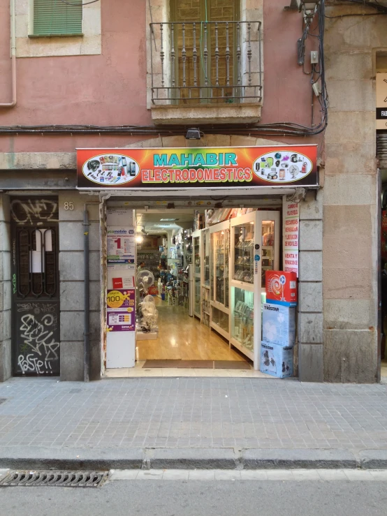 an empty street with signs and trash cans outside a building