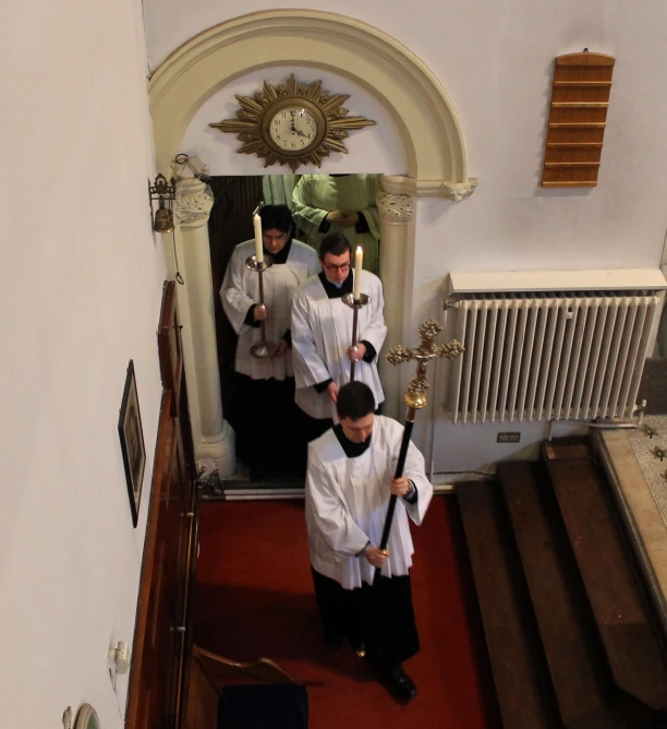 a group of men standing on the stairs holding onto sticks