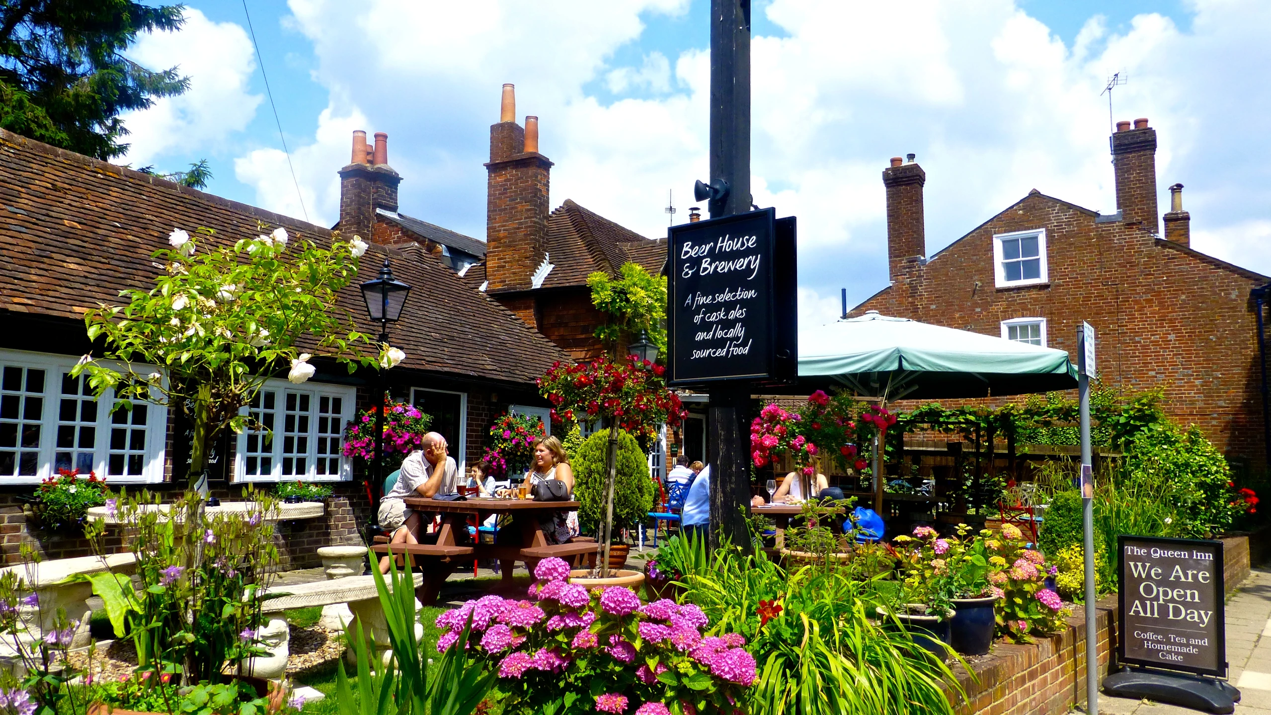 people sit outside of a small garden shop