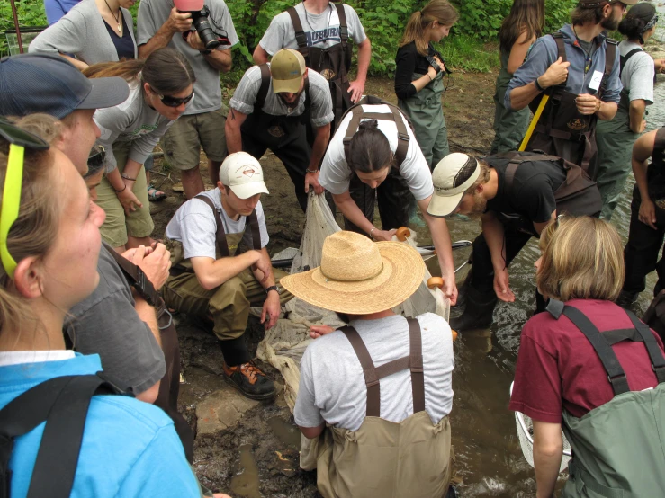 a group of people gathered around wearing hats