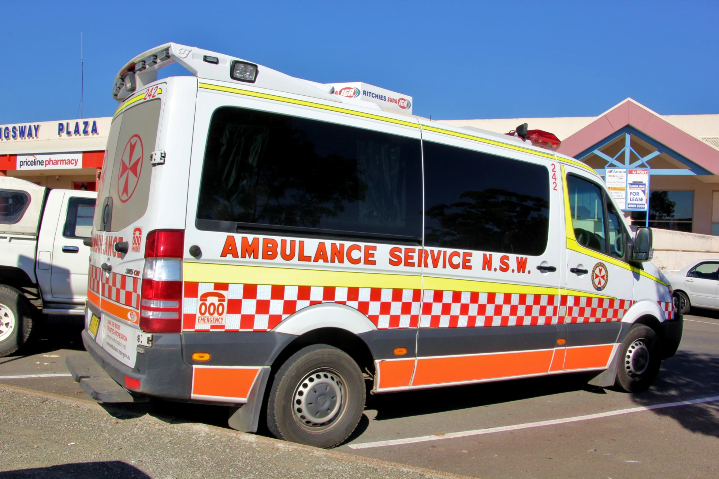 an ambulance is parked in a lot next to a building