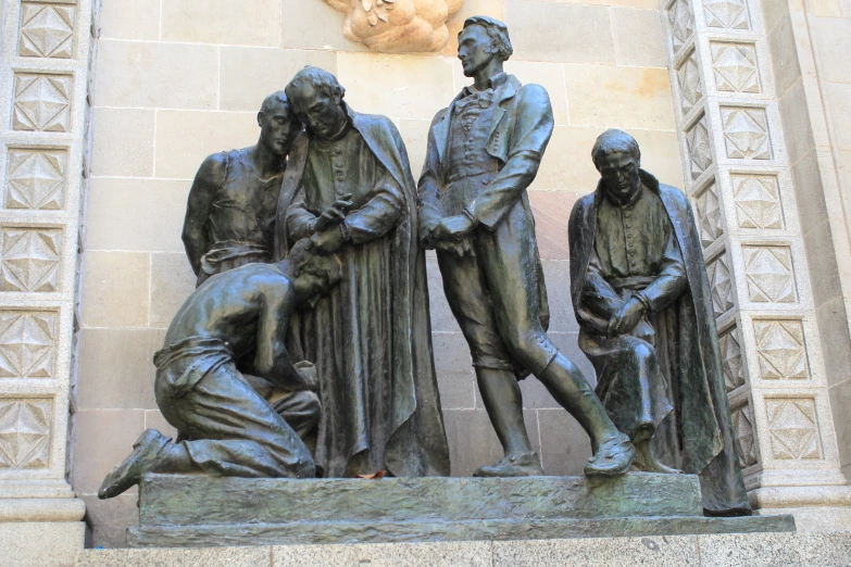 the three statue are standing close together, next to a building