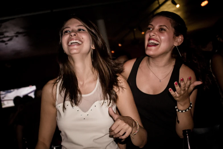two young women standing together laughing