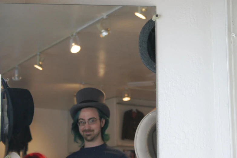 a man with green hair and a green mustache standing behind a mirror