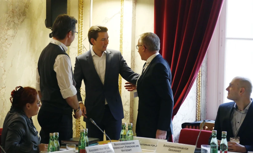 several men in suits meet with each other for a discussion