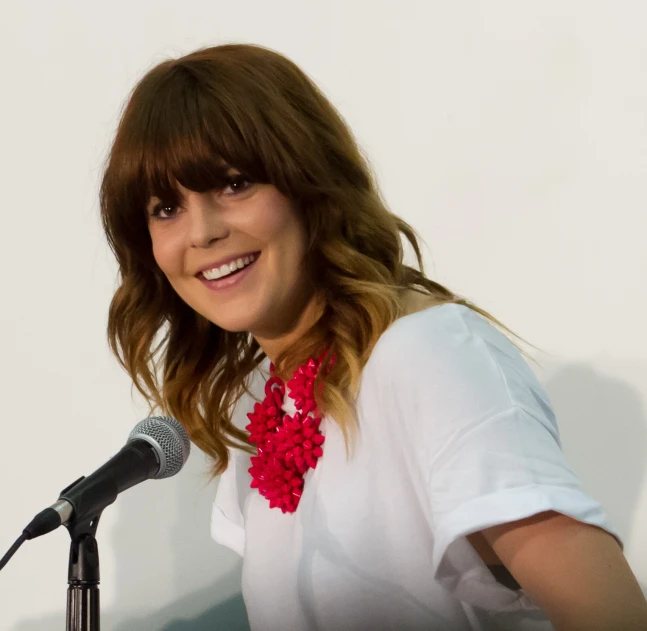 a woman sitting in front of a microphone