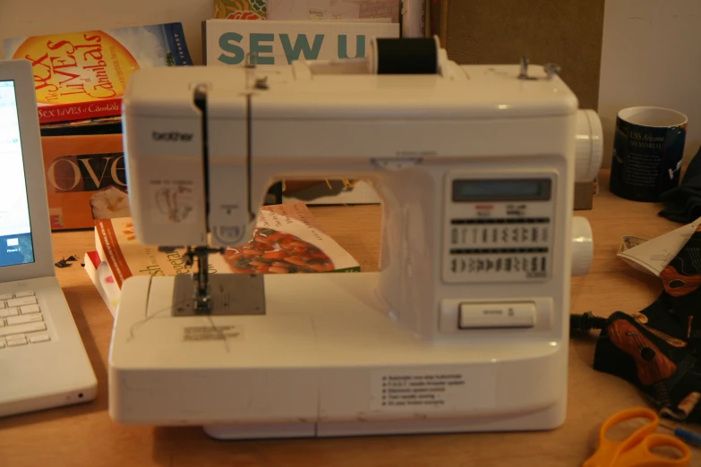 there is a white sewing machine on the table