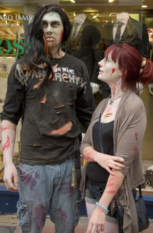 a couple dressed in costume and makeup standing outside