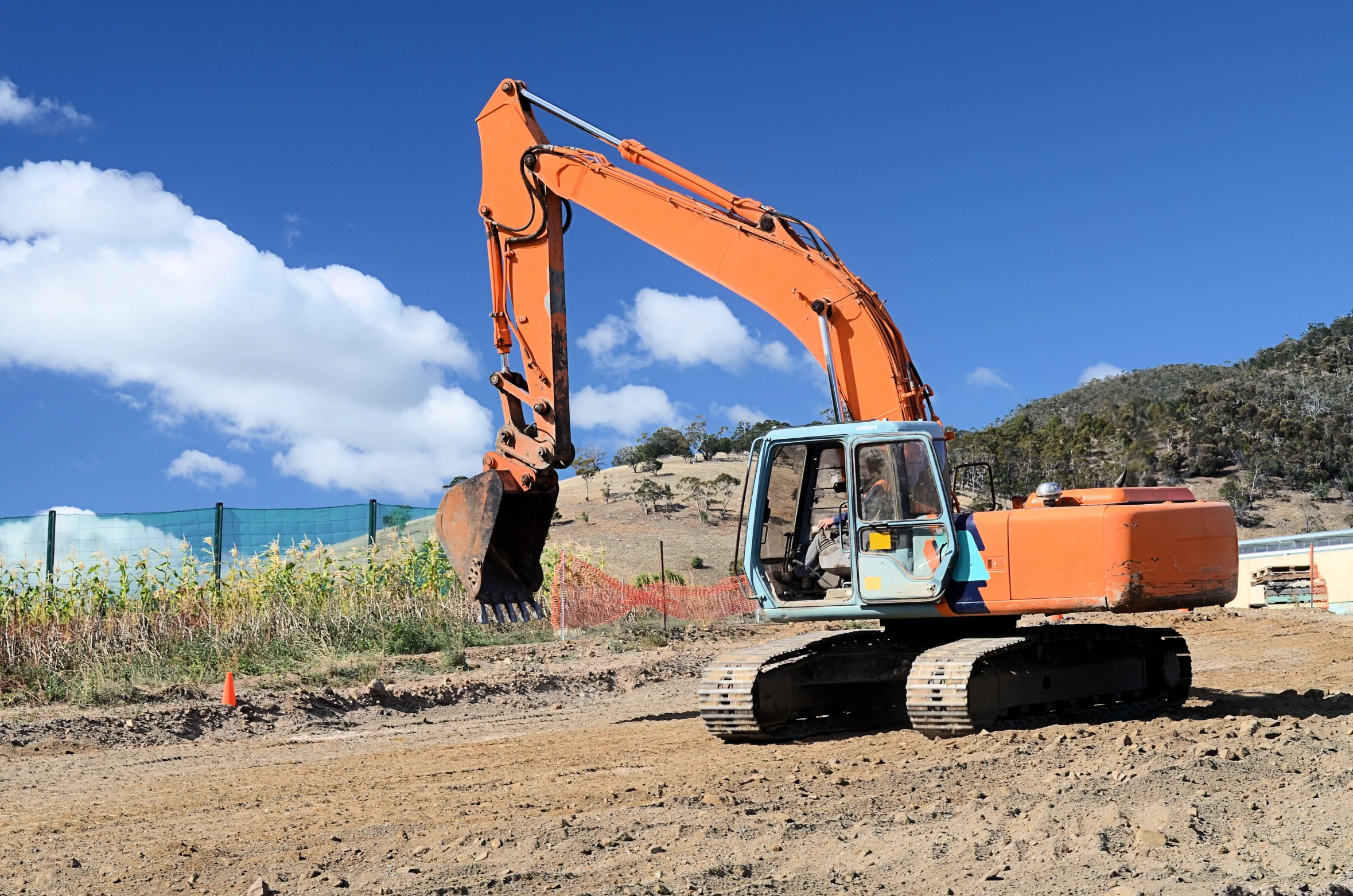 an orange and blue piece of machinery on dirt