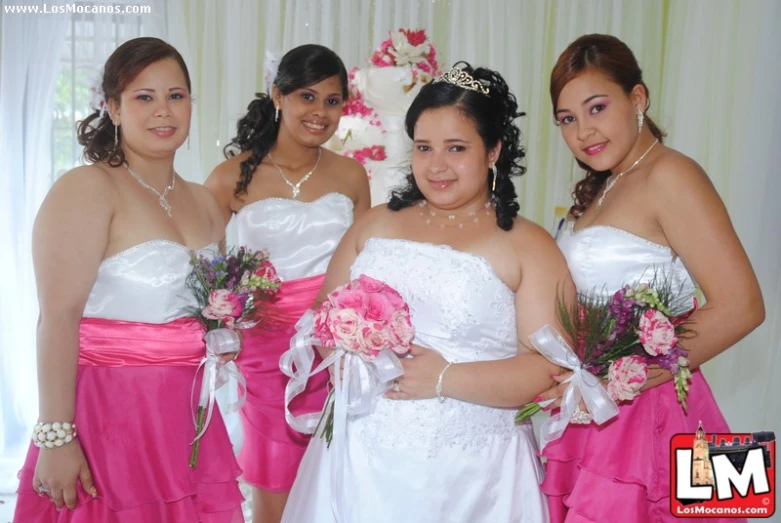 three women are dressed in wedding clothes, one is holding a bouquet