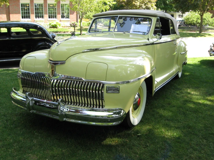 a lime green car parked in a field next to other cars