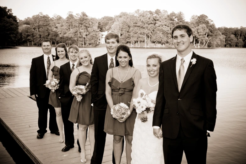 the bridal couple is posing on a pier