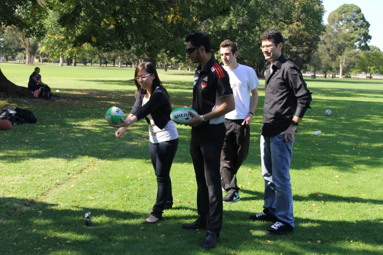 group of people with frisbees on field and trees