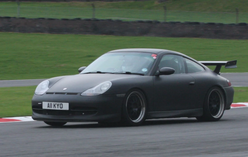 a grey porsche gtw driving on a track