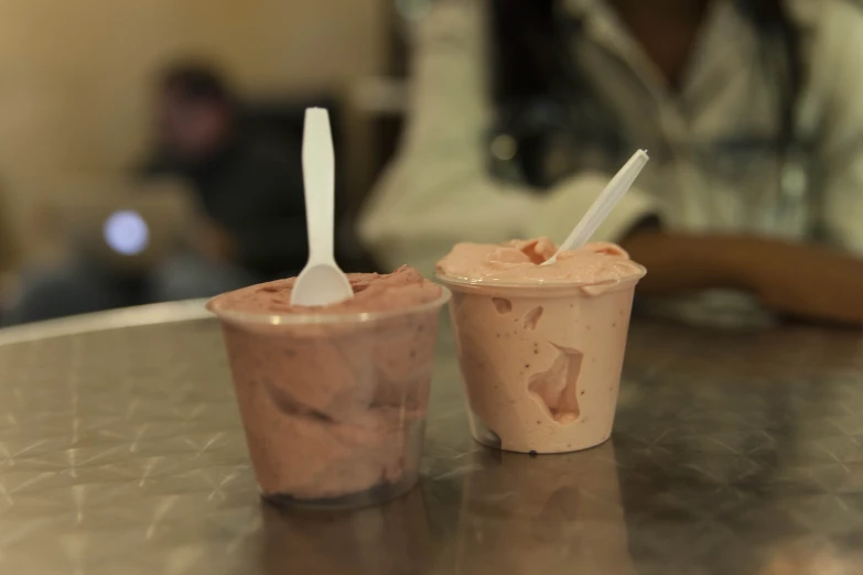 two frozen coffee drinks in plastic cups sitting on a table