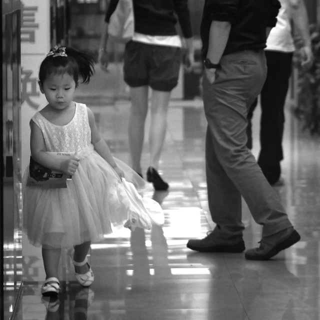 a black and white image of a little girl in a dress