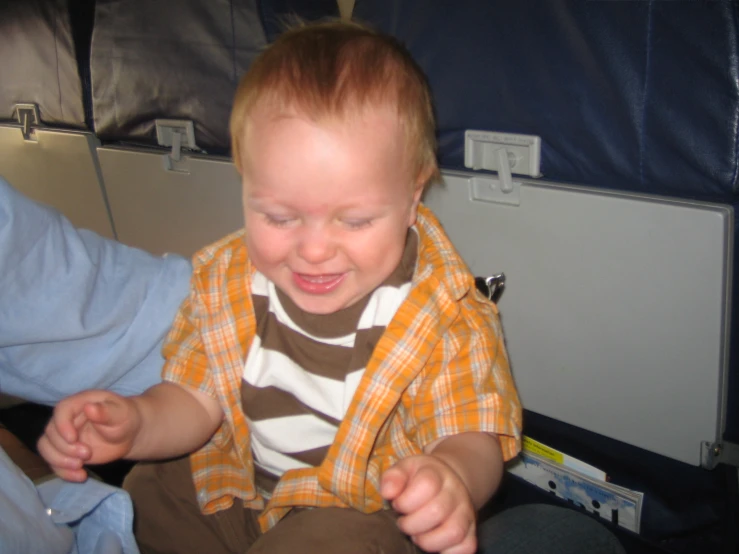 a toddler laughs with his eyes closed