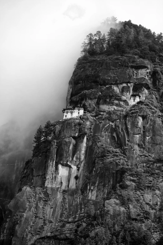 the top of a mountain is covered in low lying clouds