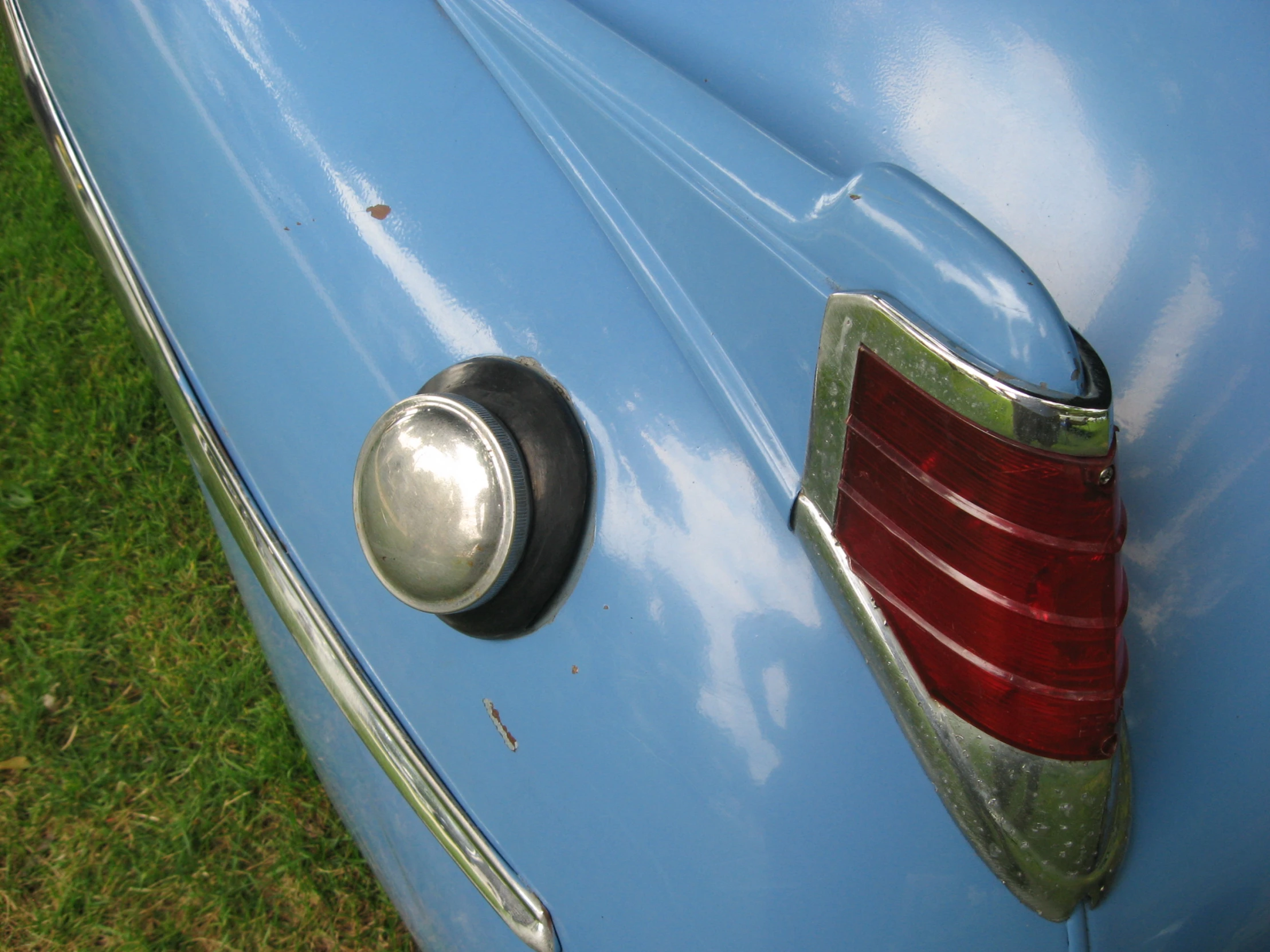 a close up po of a tail end of a blue car