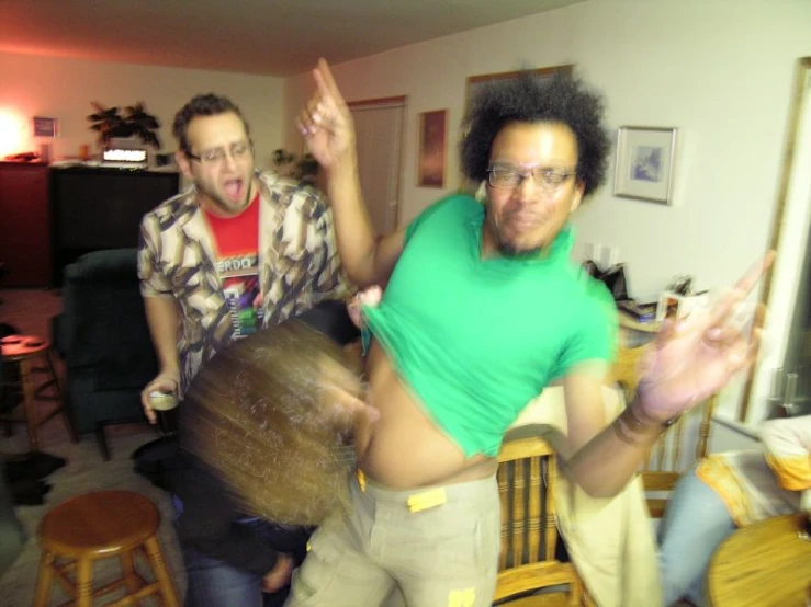 two young men are dancing in the living room