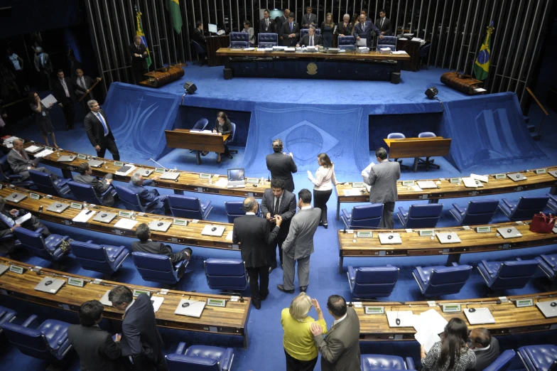 a group of people in suits standing next to each other in front of blue seats