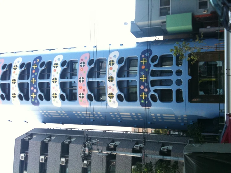 a tall blue building is painted with brightly colored images