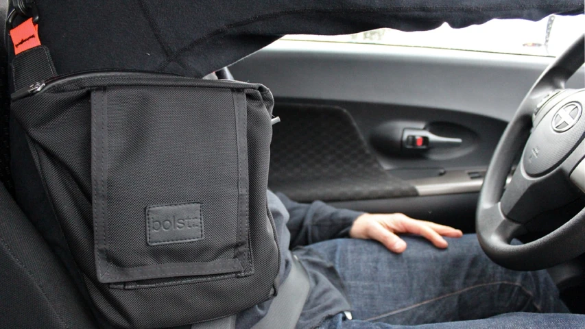 a person with their hand resting in the center console of a vehicle