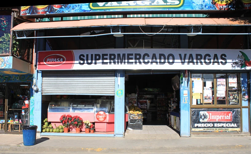 a colorful store front has some vegetables outside