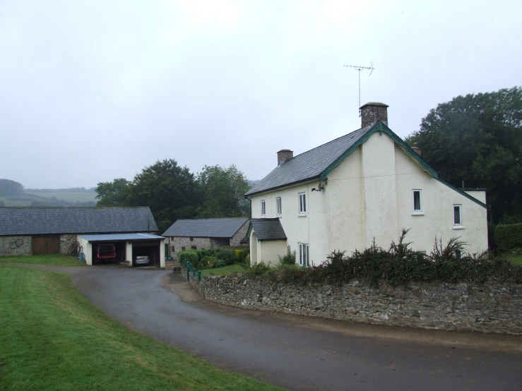 a house with a car parked beside it and grass on the ground