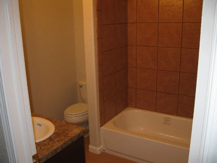 a bathroom with tiled walls, a shower and sink