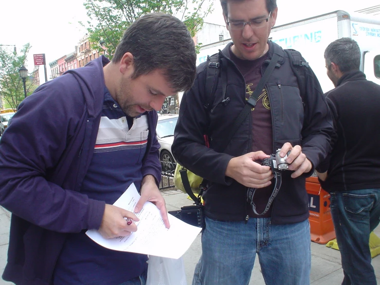 a man standing next to a man with a camera