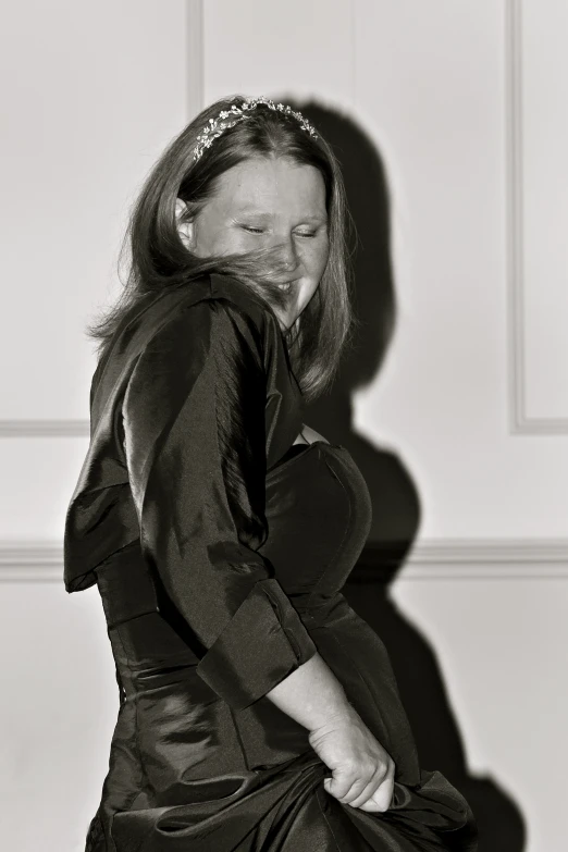 black and white po of woman standing in front of wall