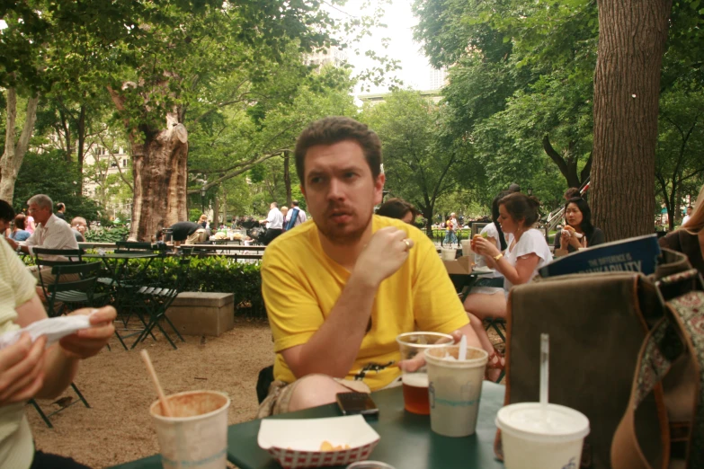 the people are enjoying their meal at the park