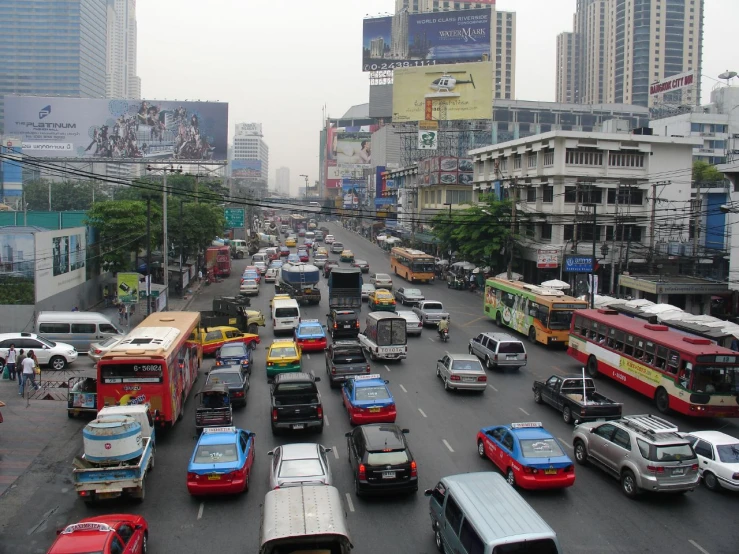 cars and buses travel down a busy city street