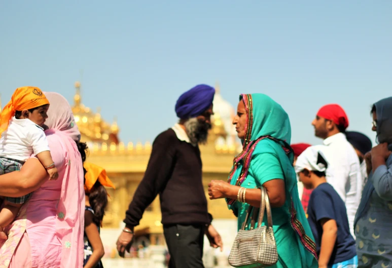 a group of people gathered outside the golden temple in india