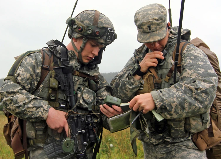 two soldiers looking at a map and gun