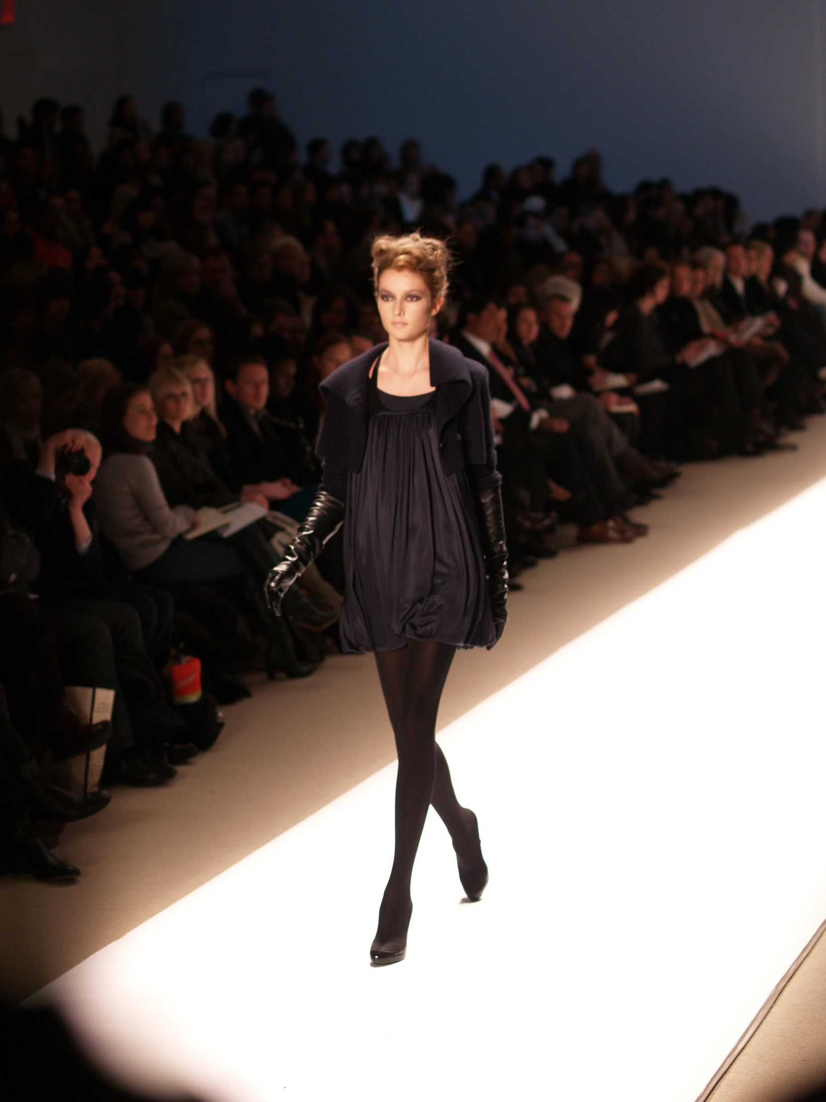 a model walking down the catwalk wearing black