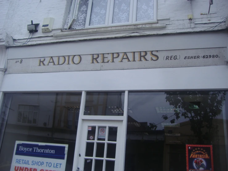 store front with windows and advertits displayed in front