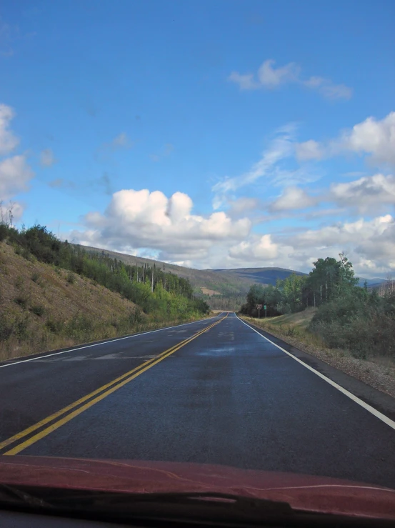 a long road with some hills in the background