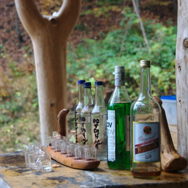 a wooden bench with bottles and glasses on it