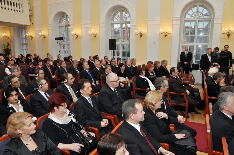 people in suits and ties seated on the floor